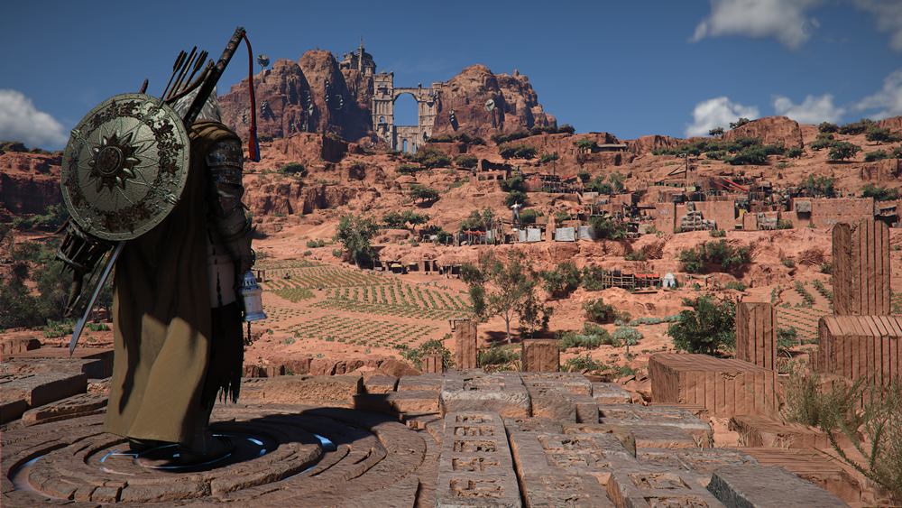 Weite Landschaft in Crimson Desert mit einer Spielfigur, Feldern, Felsen und einer großen Ruine im Hintergrund.