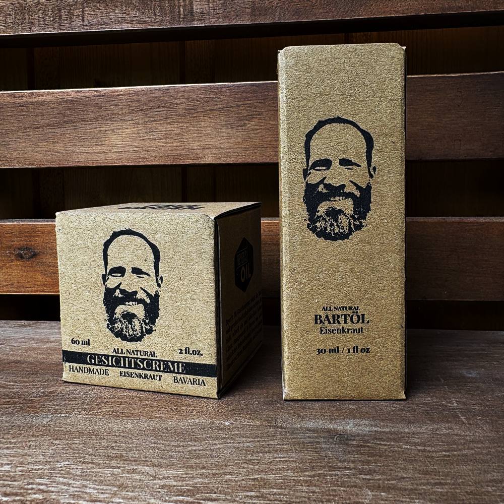 Verpackungen von Beyer’s Oil Gesichtscreme und Bartöl Eisenkraut auf einer Holzbank