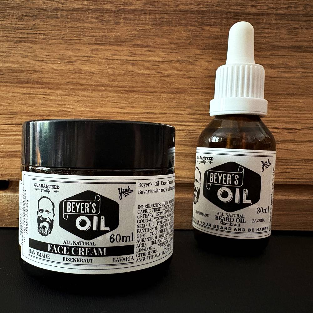 Beyer’s Oil Gesichtscreme und Bartöl nebeneinander vor einem Holzhintergrund